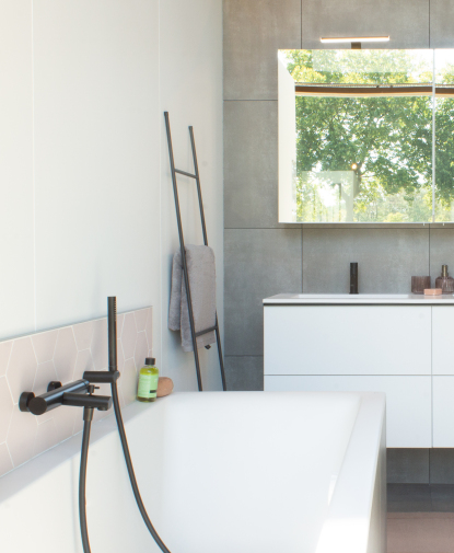 Modern badkamer met zwarte kranen en betonlook tegels